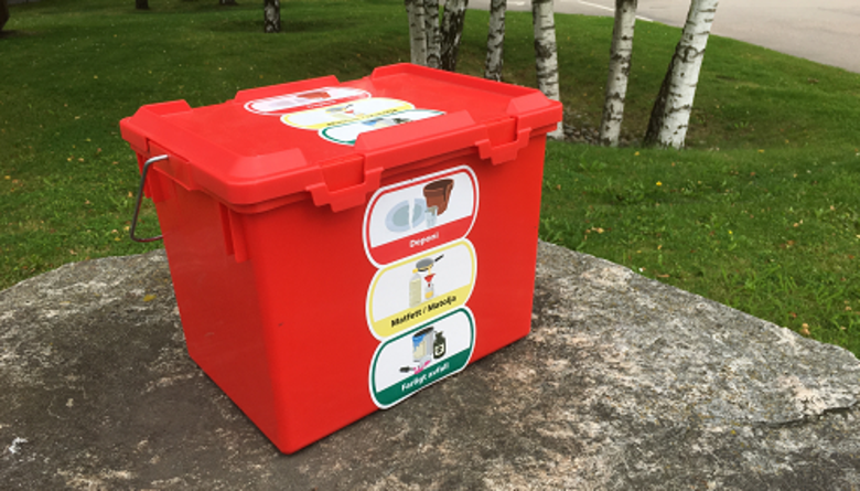 Röd plastbox med dekaler för farligt avfall, matfett och deponi.